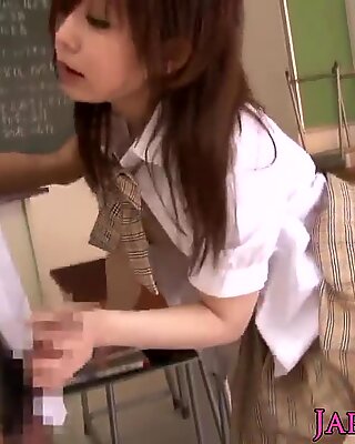 Petite asiatisk skolejente pult i klasserommet